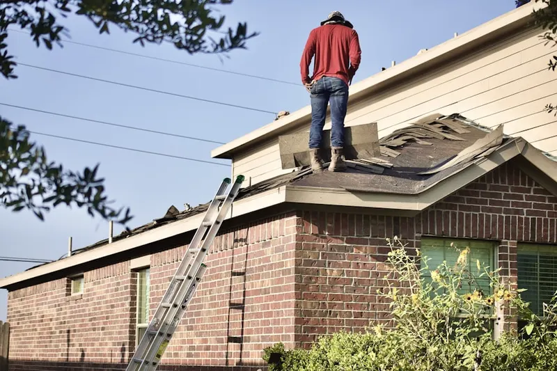 Professional roofer working on a residential roof in Etra